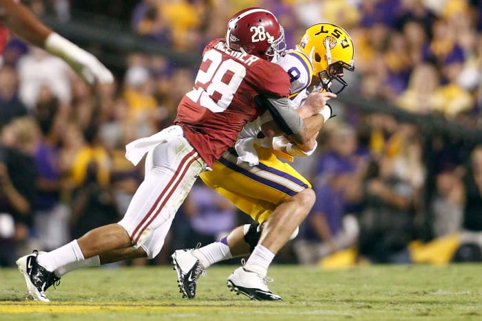 LSU Tigers quarterback Zach Mettenberger (8) is sacked by Alabama Crimson Tide defensive back Dee Milliner (28) during the first half at Tiger Stadium.